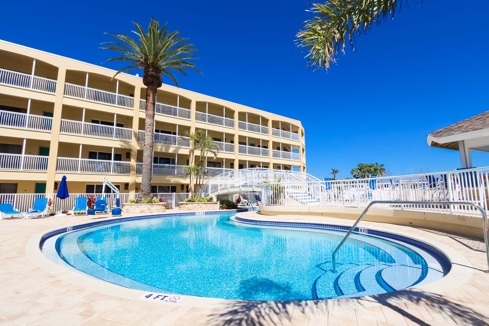 A peaceful outdoor swimming pool at VRI's Coral Reef Beach Resort in St. Pete Beach, Florida.